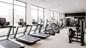 Ein Fitnessstudio mit Laufbändern, Crosstrainern und Kraftgeräten.