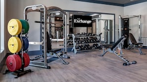 A gym with weightlifting equipment, dumbbells, and a bench. - Landing | Amazing 2BD, Gym, Pool (Jacksonville)