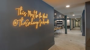 A modern interior with a neon sign reading "This Must Be the Place @ The Exchange Jacksonville" on a dark wall. - Landing | Amazing 2BD, Gym, Pool (Jacksonville)