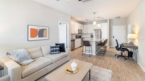Een modern appartement met een woonkamer, keuken en eethoek.