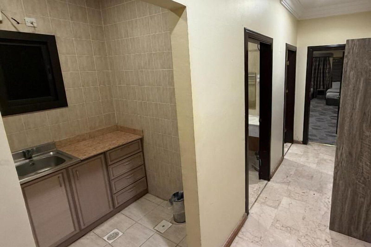 A compact kitchen with a sink, countertop, and cabinets.