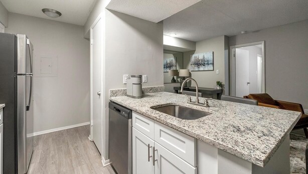 A modern kitchen with a granite countertop, stainless steel sink, and a dishwasher. - Landing | Stunning 1BD, Clubhouse, Pool (Atlanta)