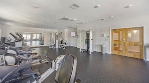 A gym with treadmills, weight machines, and a mirror wall. - Landing | Stylish 1BD, Pool, Courtyard (Richmond)