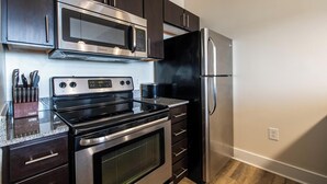 Una cocina moderna con electrodomésticos de acero inoxidable, incluyendo un microondas, horno y refrigerador.