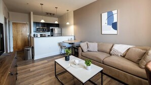 Una sala moderna con sofá, mesa de centro y un comedor con sillas.
