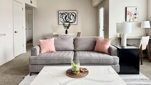 En moderne stue med en grå modulsofa, et hvidt sofabord og en minimalistisk indretning.