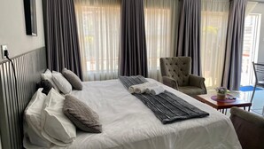 Een hotelkamer met een bed, een stoel en een klein tafeltje.