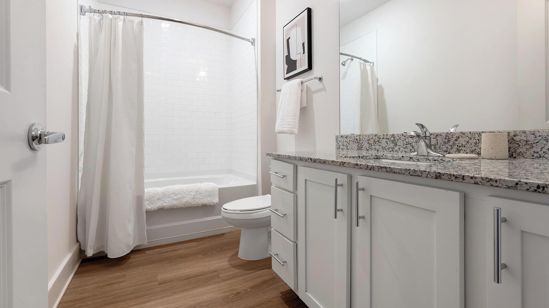 A modern bathroom with a shower, toilet, and vanity.
