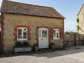 A brick house with a tiled roof, a white door, and two windows. - Granary Cottage (Chippenham)