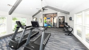 A gym with treadmills, exercise balls, and a ceiling fan. - Landing | Stunning 1BD, Courtyard, Pool (Nashville)