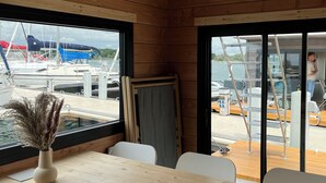 Ein Holzinnenraum mit Blick auf Boote vor dem Fenster.