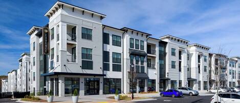 A multi-story residential building with a modern architectural design, featuring balconies and large windows.