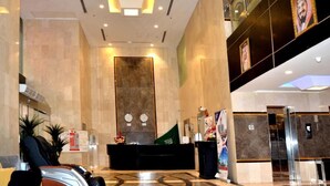 A hotel lobby with a reception desk, seating area, and a large wall with framed pictures. - Mira Al Rawda Hotel Makkah (Makkah)