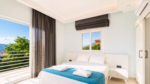 Una camera da letto con un letto, una finestra vista, un balcone e un condizionatore.