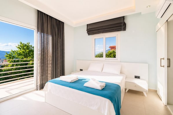 Een slaapkamer met een bed, een raam met uitzicht, een balkon en een airconditioning.
