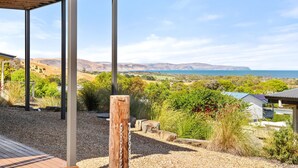 Un espace extérieur abrité offrant une vue sur la mer et les collines.