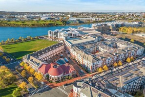 Vista aérea de un campus con varios edificios, un estacionamiento y un río al fondo.