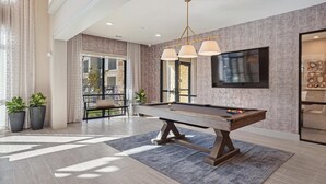 A spacious room with a pool table, a comfortable seating area, and a large TV mounted on the wall. - Landing | Spectacular 1BD, Yoga Studio, Pool (Anna)