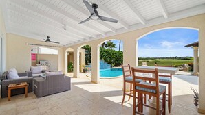 Un espace extérieur aménagé avec une terrasse, une piscine, des sièges et une vue sur le paysage.