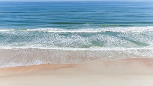 Una playa con una amplia extensión de arena y olas suaves.