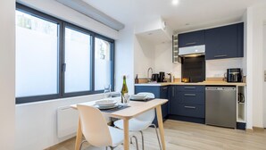 Een moderne keuken met een eethoek, grote ramen en een vaatwasser.