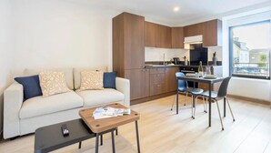 Een modern appartement met een zithoek, kitchenette en eethoek.