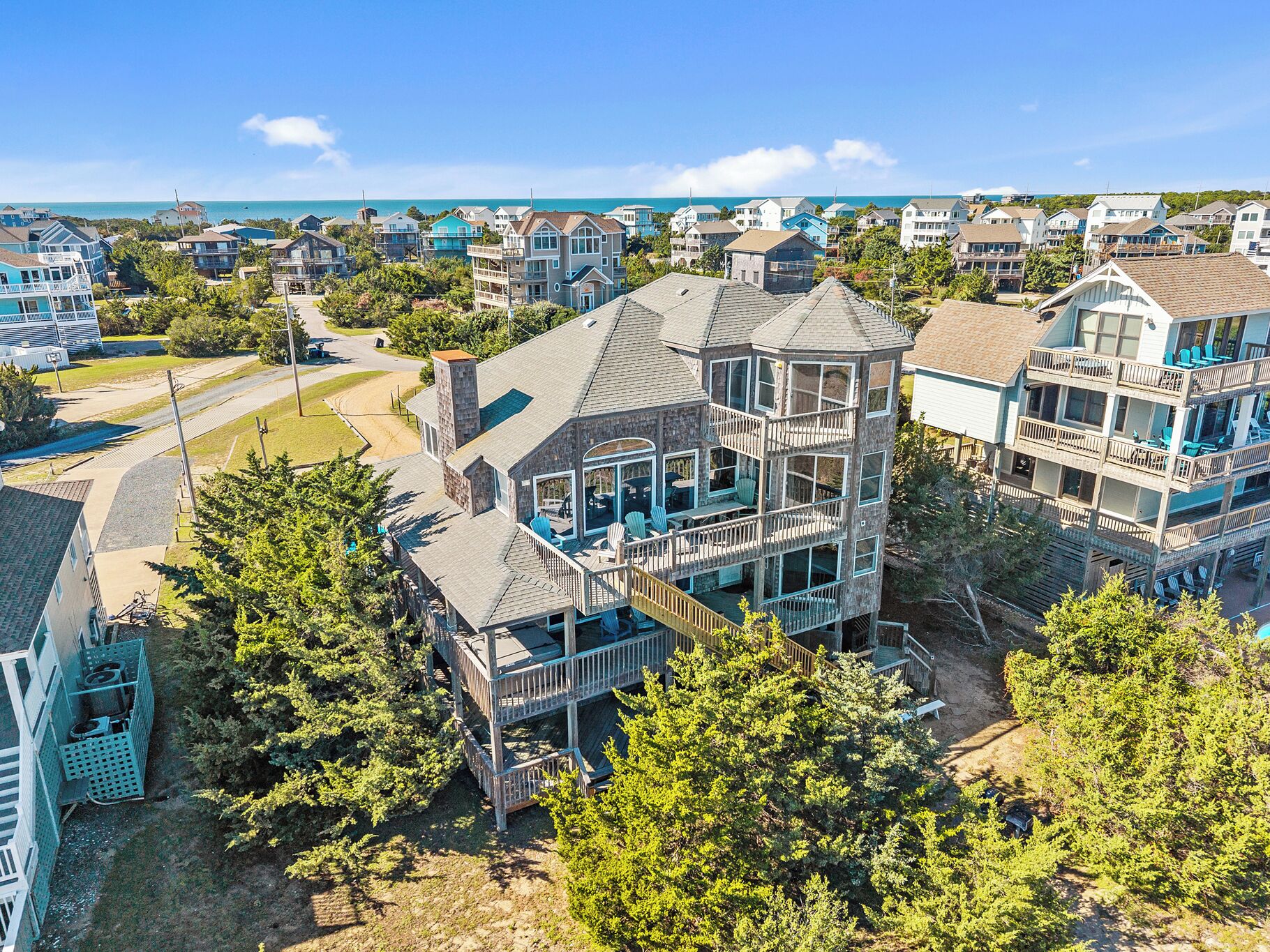 A multi-story house with a balcony and a view of the ocean.