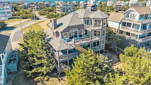 A multi-story house with a balcony and a view of the ocean. - Moon Palace: Oceanfront | Elevator | Hot Tub | Private Pool | Game Room (Salvo)