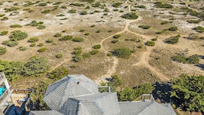 A coastal property with a sandy beach, sparse vegetation, and a clear view of the ocean. - Moon Palace: Oceanfront | Elevator | Hot Tub | Private Pool | Game Room (Salvo)