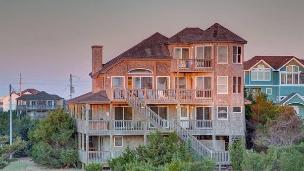 A multi-story house with a balcony and a staircase leading to the upper floor. - Moon Palace: Oceanfront | Elevator | Hot Tub | Private Pool | Game Room (Salvo)