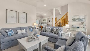 A spacious living room with a grey sofa set, a white coffee table, and a staircase leading to another level. - Marga-Lisa: Private Pool | Wet Bar | Ensuite Bedrooms (Corolla)