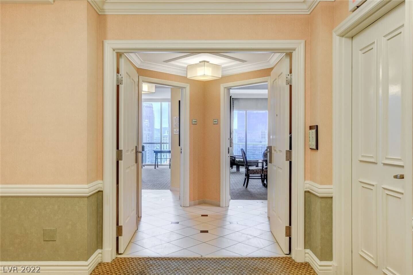 A hallway with a view of a balcony and a dining area.