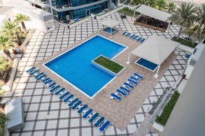 A rooftop swimming pool with lounge chairs and a covered seating area. - Dreamy 2BR at Dubai Marina (Dubai)