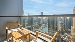 Un balcón con vista a un paisaje urbano, incluyendo edificios altos y una masa de agua.