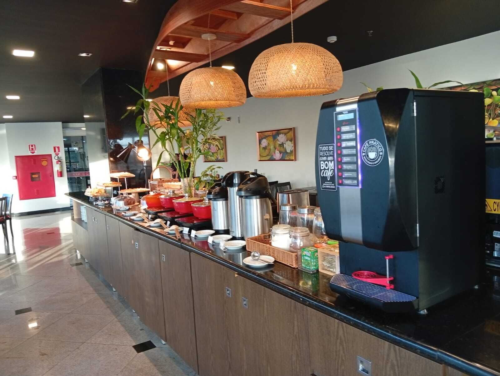 Una estación de café con una máquina de café, varios recipientes y un extintor rojo.