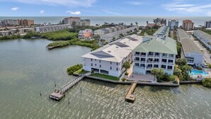 A coastal hotel with a dock, a pool, and a view of the ocean. - 🌅 Captain’s Cove 402 | 2BR Condo Across from Indian Shores Beach (Indian Shores)