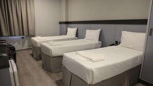Una habitación de hotel con dos camas individuales, un escritorio pequeño y una silla.