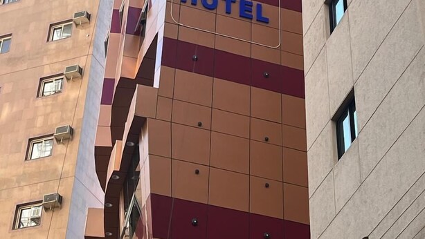 Un edificio de varios pisos con un letrero que dice Mira Nafaq Hotel.