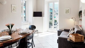 A modern apartment with a dining area, a living room, and a balcony with a city view. - Casa Vico delle Isole by Wonderful Italy (Recco)