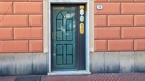 A building entrance with a dark green door, a small plaque, and a number '38' on the wall. - Casa Vico delle Isole by Wonderful Italy (Recco)