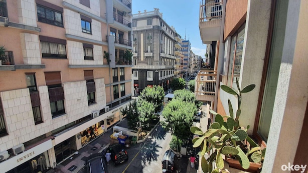 Una strada cittadina a più piani con edifici dotati di balconi e vetrine.