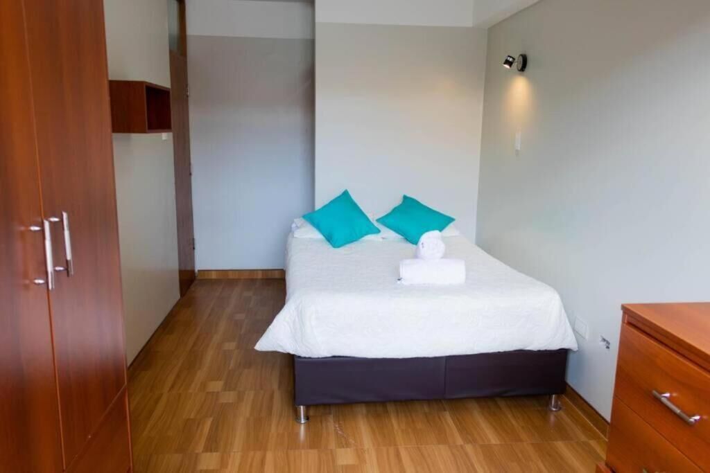 Ein Schlafzimmer mit einem Bett, einem Holzschrank und einer kleinen Kommode.