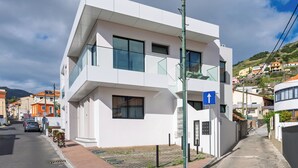 Ein modernes, zweistöckiges Gebäude mit weißer Fassade, großen Fenstern und einem gut sichtbaren Eingang.