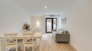 Ein modernes Wohnzimmer mit Essbereich, einer Couch und einem Tisch mit Stühlen.