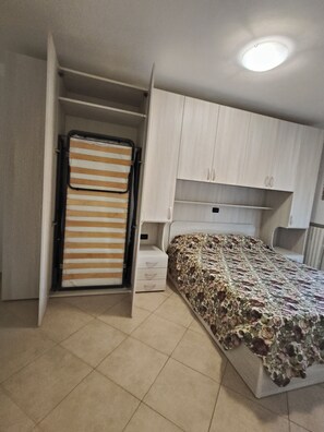 Ein Schlafzimmer mit einem Bett, einem Kleiderschrank und einem Nachttisch.
