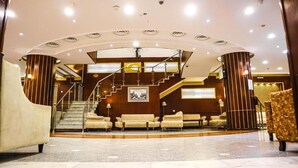 A spacious lobby with a grand staircase, plush seating, and a modern design. - Mukhtara Al Gharbi Hotel (Madinah)
