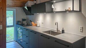 A modern kitchen with a large window, built-in appliances, and a sleek design. - 3 bedroom gorgeous home in Sæby (Sæby)