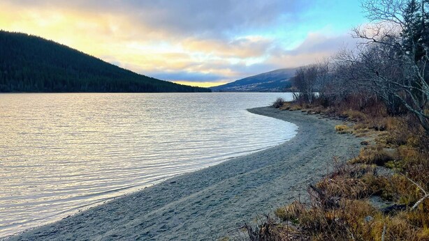 A serene lakeside view with a sandy beach, surrounded by forested hills and a clear sky. - 1 bedroom gorgeous apartment in åre (Åre)