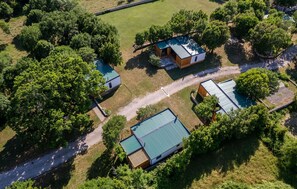 An aerial view of a property with three buildings, surrounded by dense greenery and a gravel path. - 2 bedroom beautiful home in Obrovac (Obrovac)