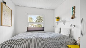 A bedroom with a bed, a window, a map on the wall, and a shelf with flowers. - Amazing home in Tarm with WiFi (Tarm)